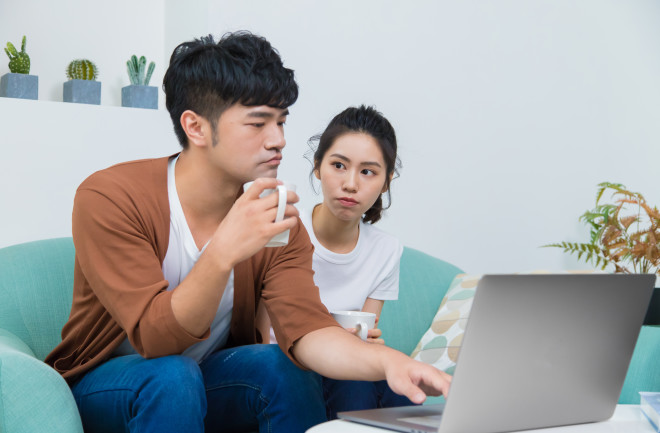 Man working seriously at home and woman looking at him. Woman wishes man accompany her more. Concept of "Love needs much care to grow".