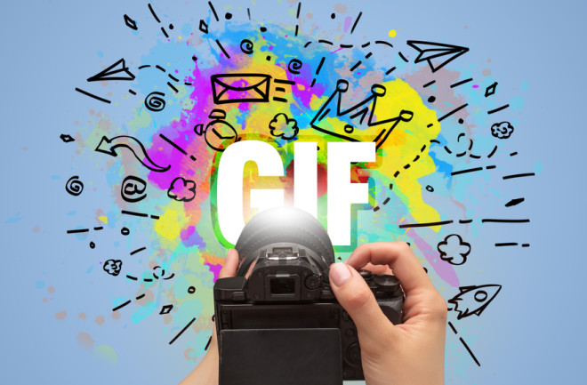 Close-up of a hand holding digital camera with abstract drawing and GIF inscription