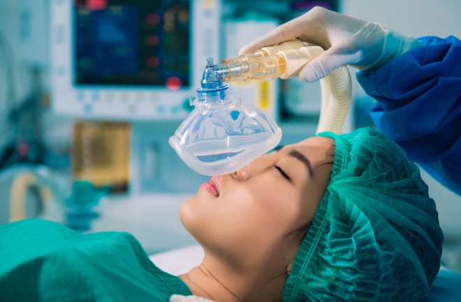 Doctor putting a female surgical patient under anesthesia with inhalation