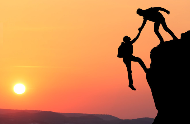 Two people on a cliff showing trustworthy behavior