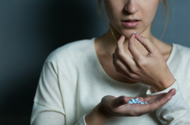 woman taking pills - shutterstock