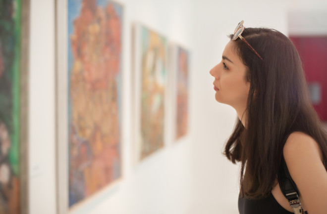 woman admiring art - shutterstock