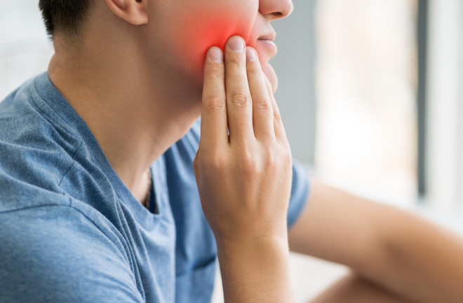 A man with toothache, wisdom tooth pain, painful area highlighted in red